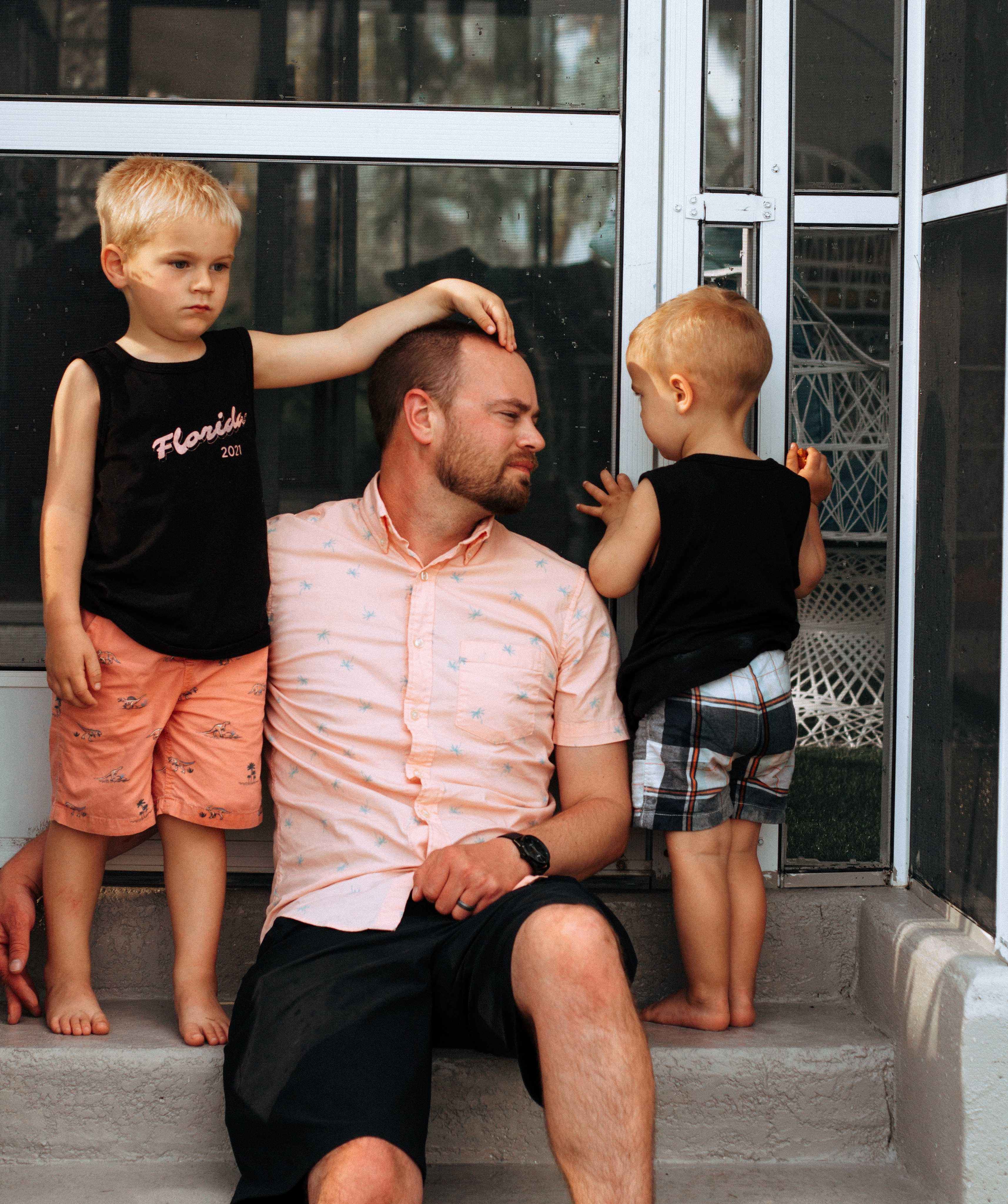 Father sitting on step with two young sons