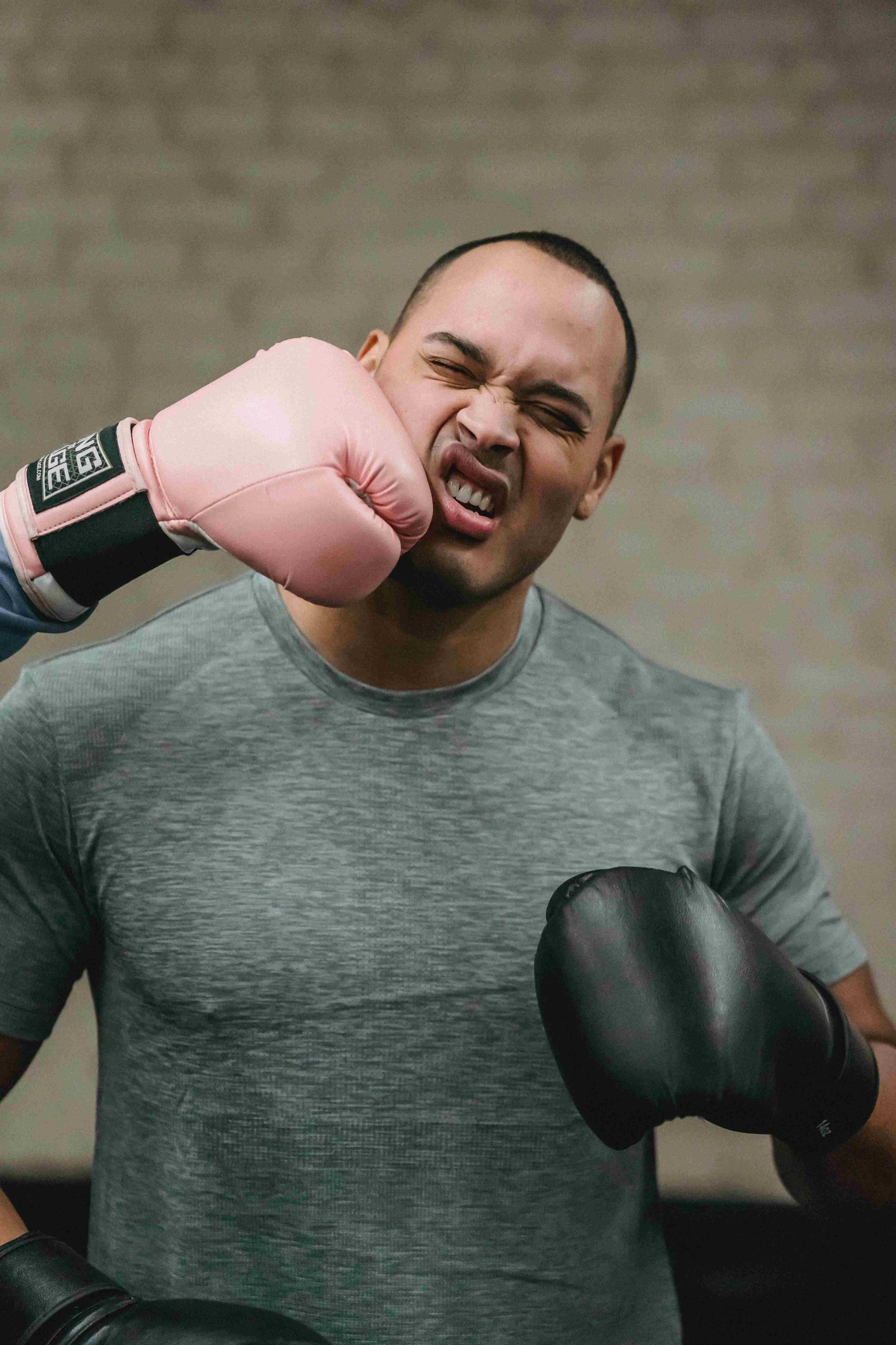 Man getting punched in face with pink boxing glove