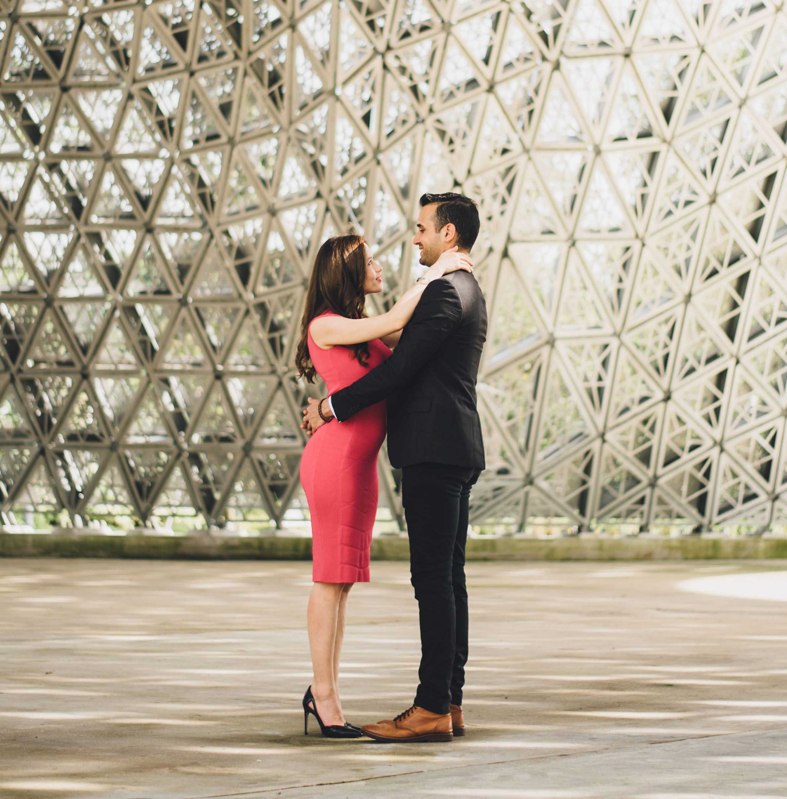 Couple embracing with crosshatched architectural feature in background